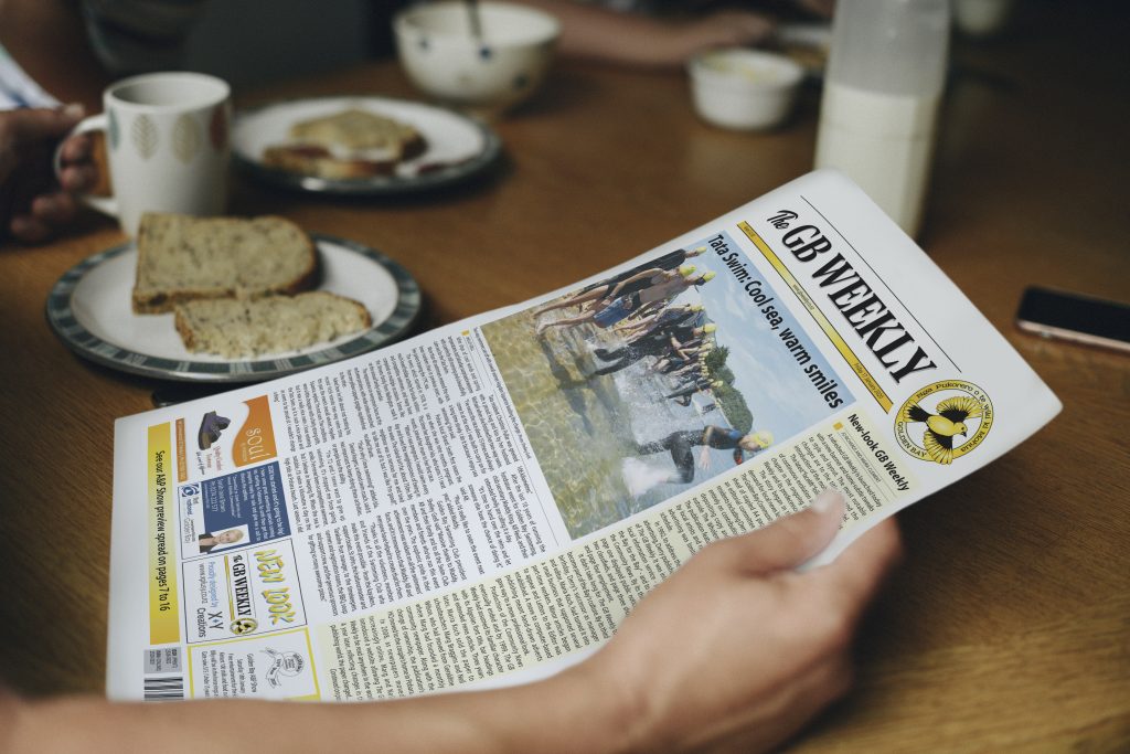 Reader at the breakfast table enjoying the new look GB weekly newspaper designed by X Plus Y Creations.